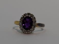 A lady's dress ring having a heat treated oval amethyst and diamond cluster in a stepped claw set