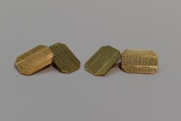 A pair of 9ct gold cufflinks of canted oblong form having engine turned striped decoration and chain