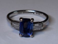 A lady's 1930's dress ring having a central cushion cut sapphire, approx 1.65ct flanked by two