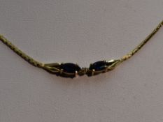 A 9ct gold necklace having a central sapphire and diamond set panel
