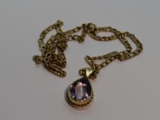 A 9ct gold fancy link chain with a tear drop style amethyst pendant in a yellow metal mount, no