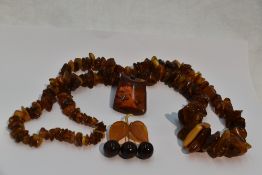 A selection of Russian amber jewellery including a brooch modelled as a trio of cherries hanging