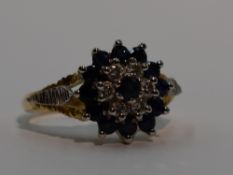 A lady's dress ring having a sapphire and diamond triple cluster to open raised shoulders on an 18ct