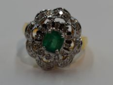 A lady's dress ring having a central emerald within a frilled double cluster of small diamonds in