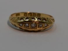 A lady's dress ring having five graduated diamond chips in a gallery mount on an 18ct gold loop,
