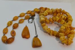Four pieces of Russian butter scotch amber including a string of rough cut beads, a pendant on a