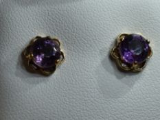 A pair of amethyst stud earrings in 9ct gold mounts