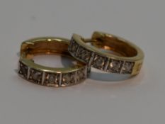 A pair of hinged hoop yellow metal earrings stamped 585 each having cubic zirconia decoration