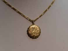 A 9ct gold locket of circular form having engraved decoration on a 9ct gold figaro chain, approx