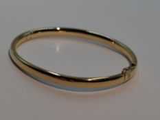 A 9ct gold hinged bangle of plain form with concealed clasp, approx 25g