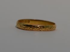 A 22ct gold wedding band having engraved scroll decoration, size V & 3.2g