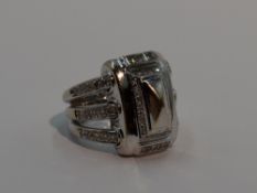 A lady's 18ct white gold dress ring by Mouawad having a large central moulded panel with diamond