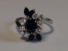 A lady's dress ring having a central sapphire, approx 0.75ct surrounded by four marquise cut