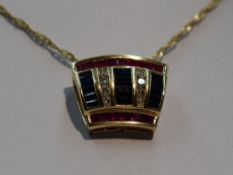 A yellow metal pendant stamped 14K set with three rows of sapphires interspersed by two rows of