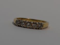 A lady's dress ring having five diamonds in a claw set raised mount on an 18ct gold loop, size M