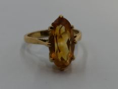 A lady's dress ring having a lozenge shaped citrine in a claw set basket mount on a yellow metal