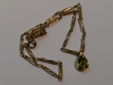 A peridot tear drop shaped pendant having diamond chip decoration in a yellow metal mount stamped 9K