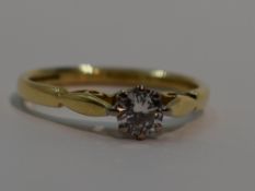 A lady's diamond solitaire dress ring, approx 0.25ct in a four claw raised mount to shaped shoulders