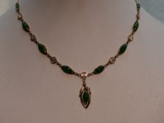 A jade necklace having eight lozenge shaped panels with a pendant drop and decorative connector