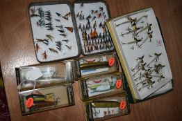 A collection of wooden and quill lures and a tin of flies.