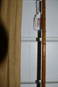 A vintage cane fishing rod approx 11ft unmarked with sleeve