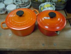 Two orange enamel Le Creuset lidded cooking pans