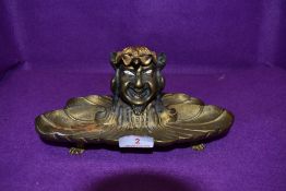 A late 19th/early 20th century gilded bronze gents desk top ink well having grotesque squatting
