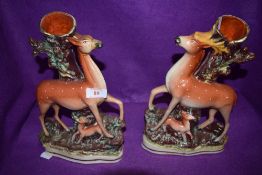 A pair of antique spill vases both in the form of tree stumps,one having deer and fawn the other