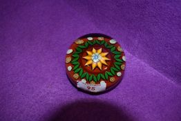A vintage paperweight having floral centre in reds,oranges and greens,Possibly Perthshire,