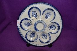 An early 20th century oyster dish in blue and white with rose pattern, marked to back Ironstone,