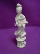 A Chinese figure or statuette in a Blanc De Chine style of Guanyin holding lotus