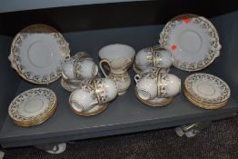 A vintage part dinner service having gilt vine pattern with blue detailing, cups and saucers,
