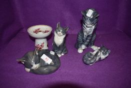 Four Royal Copenhagen cats in various positions.