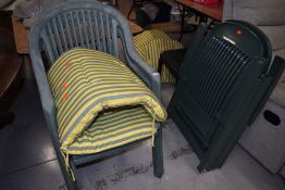 A selection of green plastic garden chairs and complementary cushions