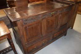 A period oak mule chest having carved frieze, three panel top section over double drawer base,
