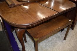 A light stained mahogany winding dining table with leaf