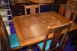 An early to mid 20th Century oak drawer leaf table and four chairs