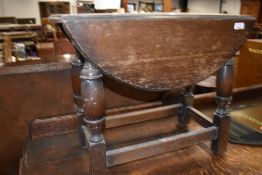 A traditional oak drop leaf twist top occasional table, width approx. 61cm