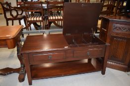 A modern maghogany effect coffee table having compartmental interior under lift lids