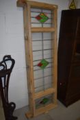 A stripped window frame with frosted leaded and coloured glass panes