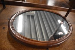 A late 19th/early 20th Century oval wall mirror, ex dressing table