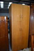 An early to mid 20th Century golden oak and sapele double cupboard, in the Gomme/G Plan style,