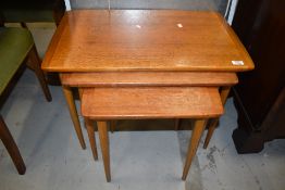 A vintage teak nest of three tables, on tapered legs