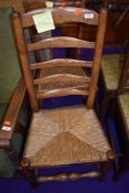 A period oak ladderback chair having rush seat and a cane seated bedroom chair