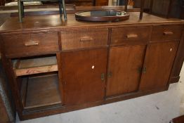 A vintage oak shop or office counter, having four frieze drawers over cupboard base having sliding