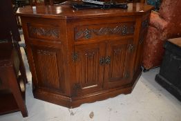 A nice quality Old Charm or similar canted side cabinet having linen fold doors, labelled on back