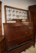 A late 19th/early 20th Century mahogany panelled bed frame, including side irons and base, width