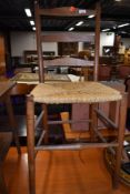 A traditional oak ladder back bedroom chair having strung seat