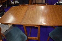 A vintage teak or sapele gateleg dining table of stylised form, similar to G plan, and four