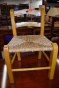A vintage beech frame child's chair having rush seat